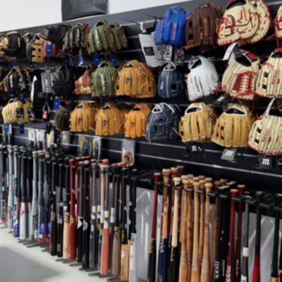 Base2Base Sports showroom wall of baseball gloves and Baseball bats